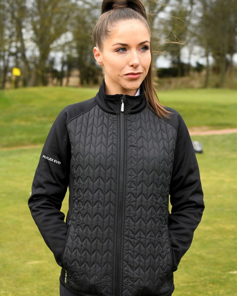 A brunette lady golfer wearing a black ProQuip ProFlex quilted jacket