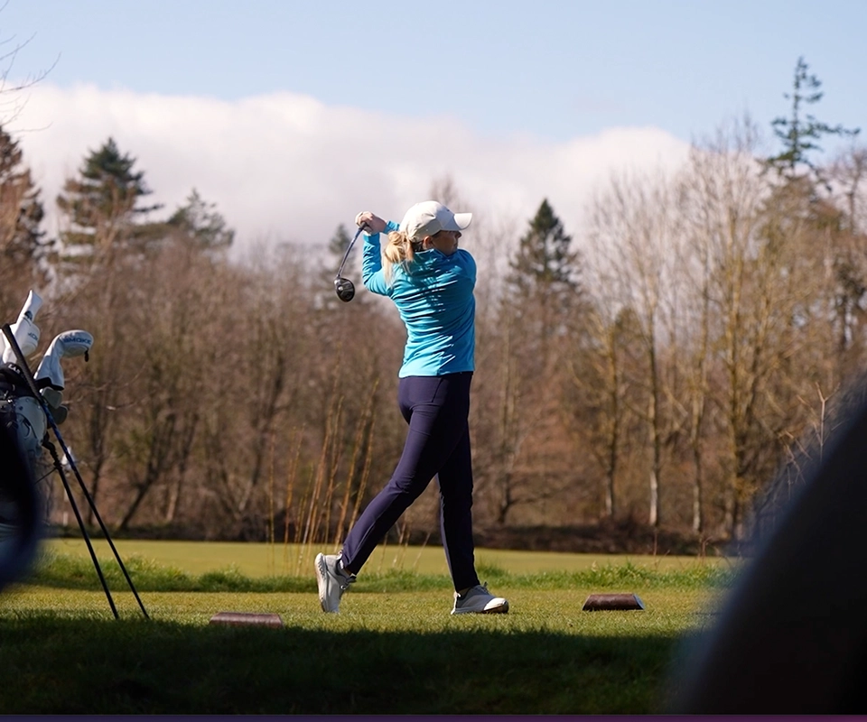 A lady golfer in full swing wearing ProQuip